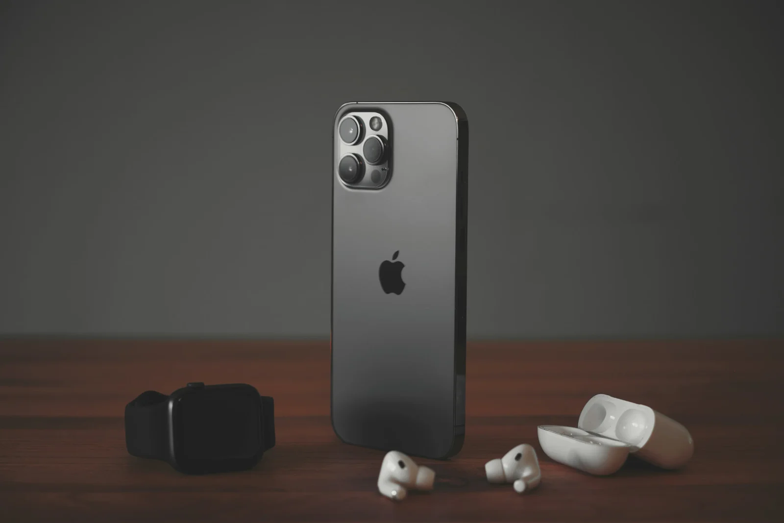 iPhone, relógio e fones sem fio sobre uma mesa