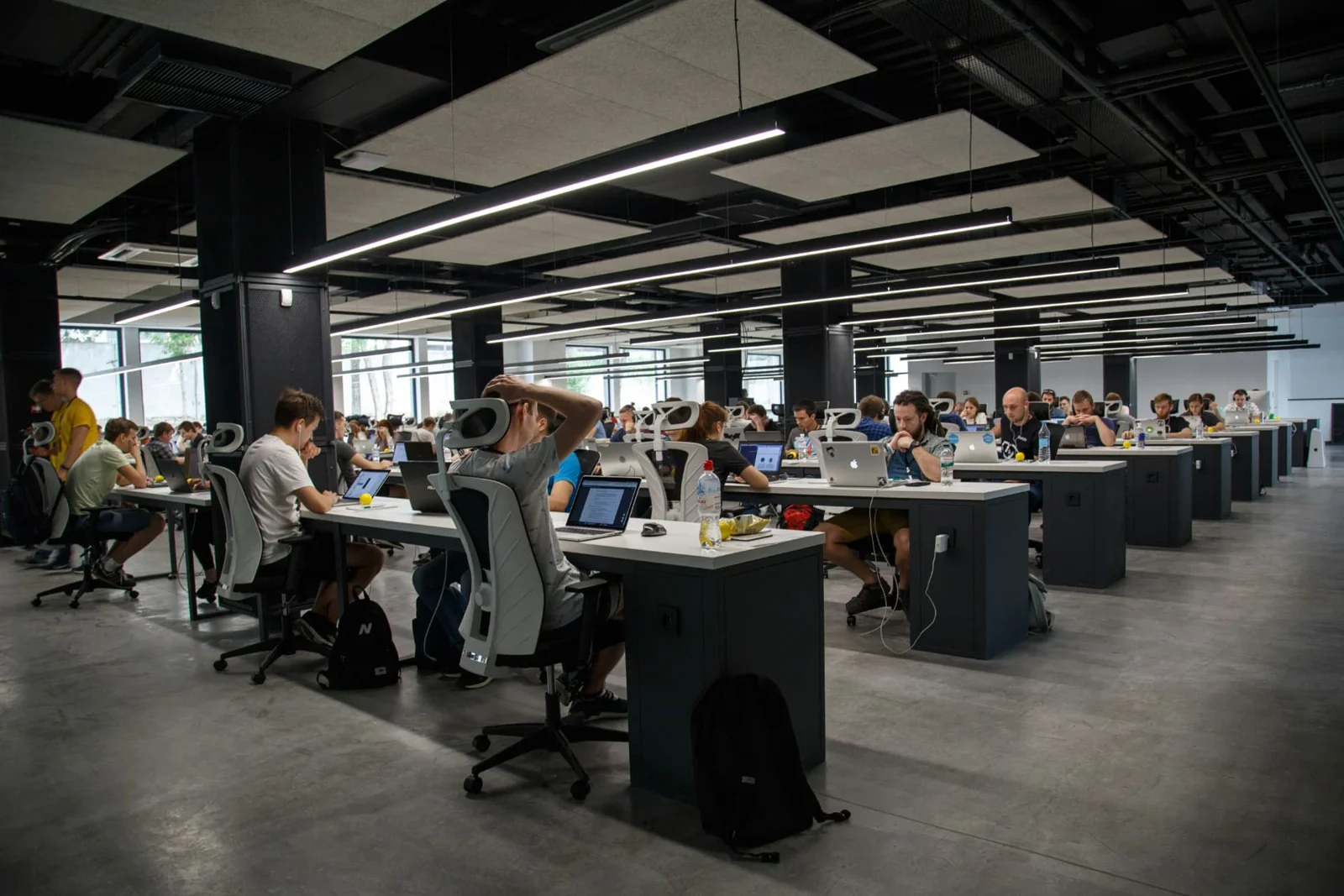 Escritório aberto com pessoas trabalhando em notebooks