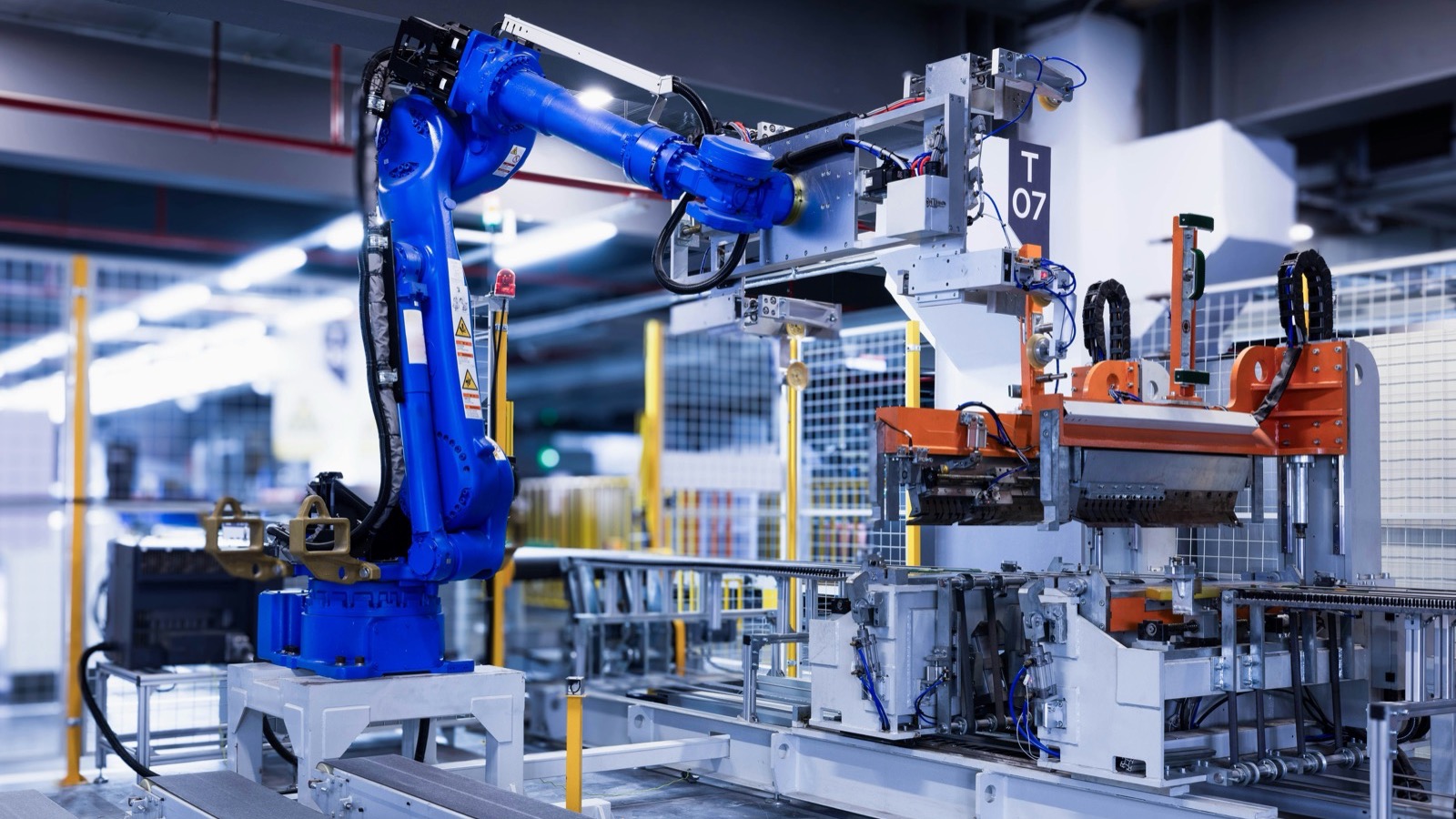Braço robótico industrial azul em uma linha de montagem de fábrica