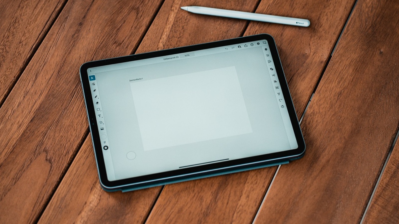 Tablet sobre uma mesa de madeira, com uma caneta branca ao lado