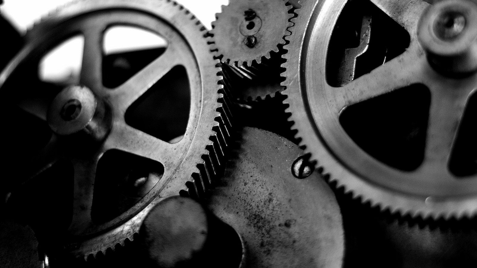 Engrenagens metálicas encaixadas, em preto e branco, em close